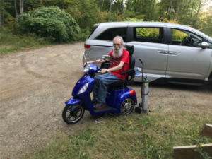 An old man on a blue scooter